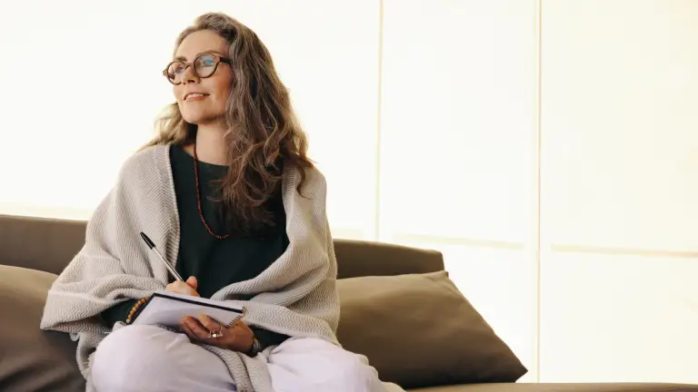 a woman reflecting and holding a journal